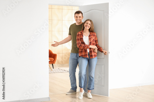 Happy couple inviting guest...