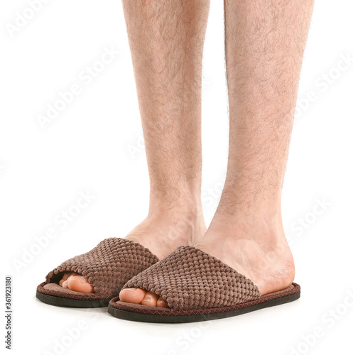 Male legs in soft slippers on white background
