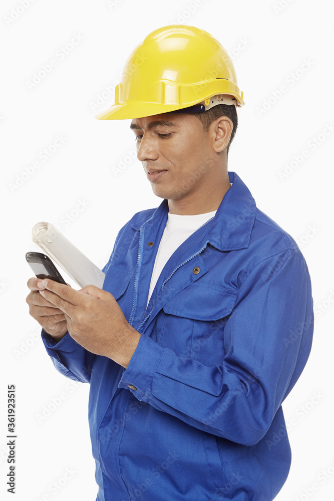 Construction worker sending a text message Construction worker sending a text message