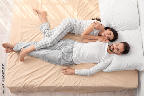 Young couple sleeping in be...