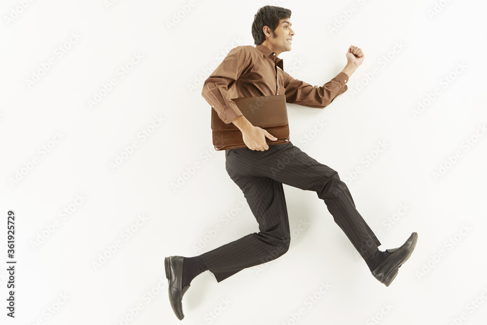 Businessman holding a briefcase and running