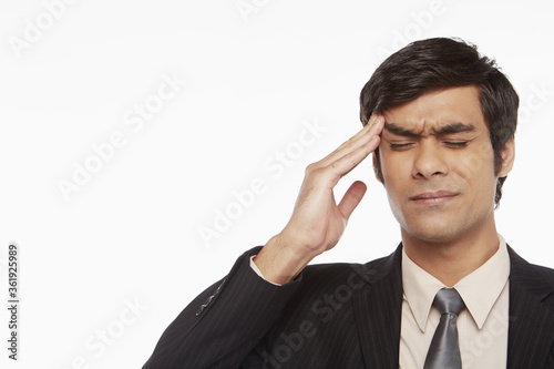 Businessman touching his forehead