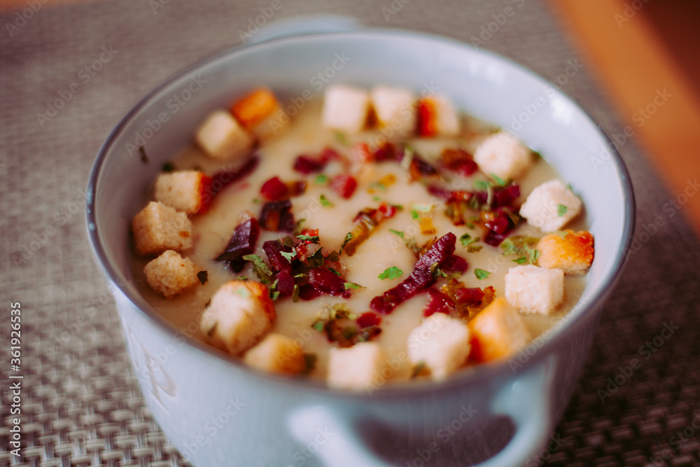 Zuppa soup di patate, con scalogno, erba cipollina, prezzemolo, pezzetti di prosciutto crudo e crostini di pane in una ciotola mono porzione in ceramica Zuppa soup di patate, con scalogno, erba cipollina, prezzemolo, pezzetti di prosciutto crudo e crostini di pane in una ciotola mono porzione in ceramica