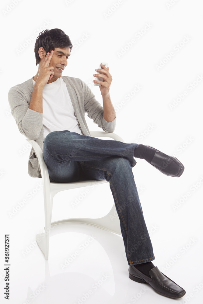 Man sitting on a chair, text messaging
