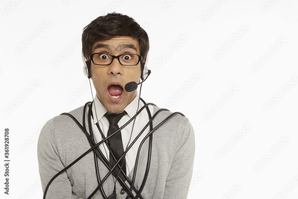 Man with headset wrapped in a tangled cable Man with headset wrapped in a tangled cable