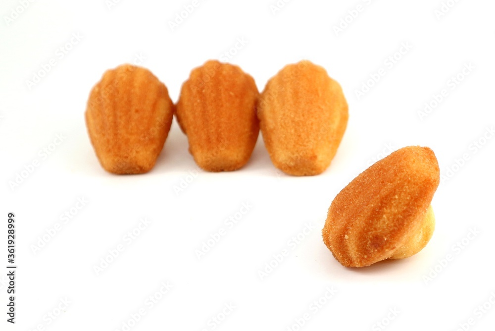 Madeleine, or Madeleinette, traditional small french cake on white background. It is a small sponge pastry item, shell shaped. Madeleine, or Madeleinette, traditional small french cake on white background. It is a small sponge pastry item, shell shaped.