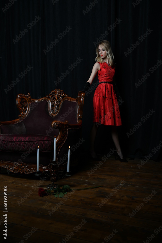 young and beautiful girl in a red dress and a brown armchair