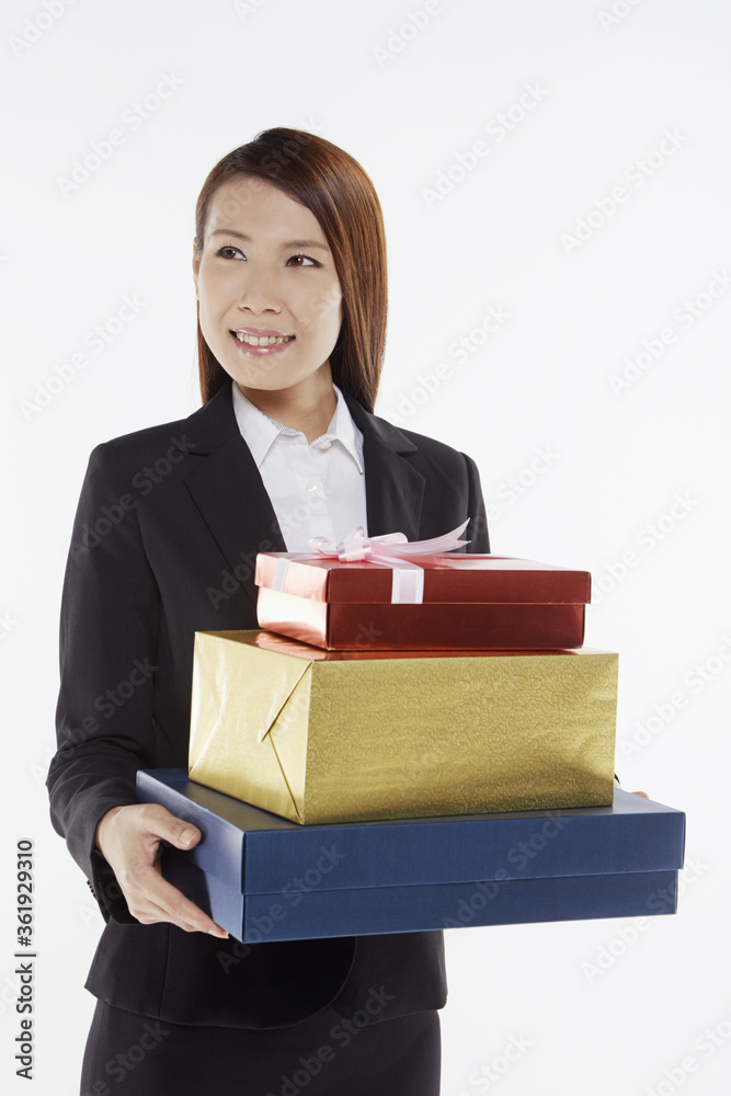 Businesswoman carrying a stack of gift boxes Businesswoman carrying a stack of gift boxes