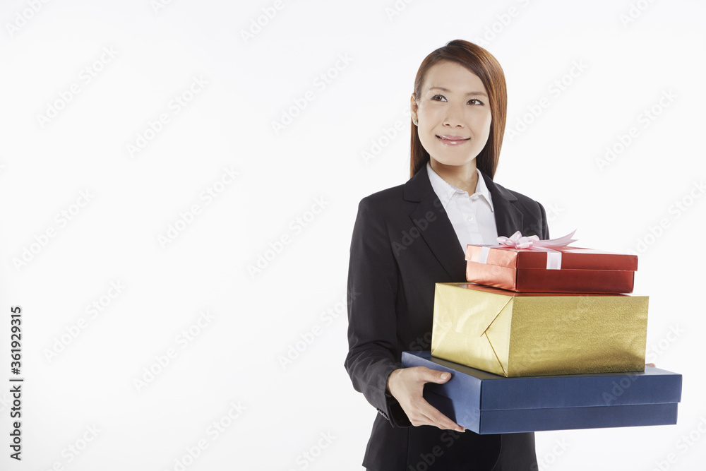 Businesswoman carrying a stack of gift boxes Businesswoman carrying a stack of gift boxes