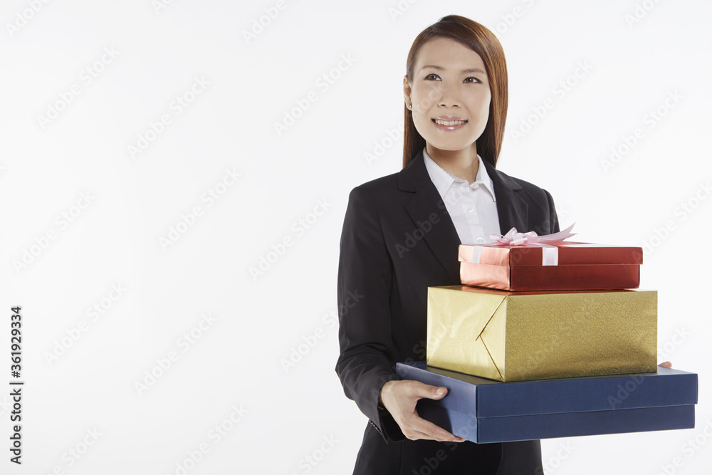 Businesswoman carrying a stack of gift boxes Businesswoman carrying a stack of gift boxes