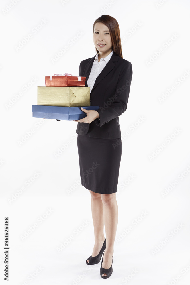 Businesswoman carrying a stack of gift boxes Businesswoman carrying a stack of gift boxes
