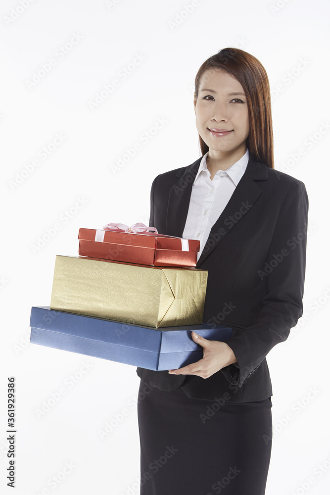 Businesswoman carrying a stack of gift boxes Businesswoman carrying a stack of gift boxes