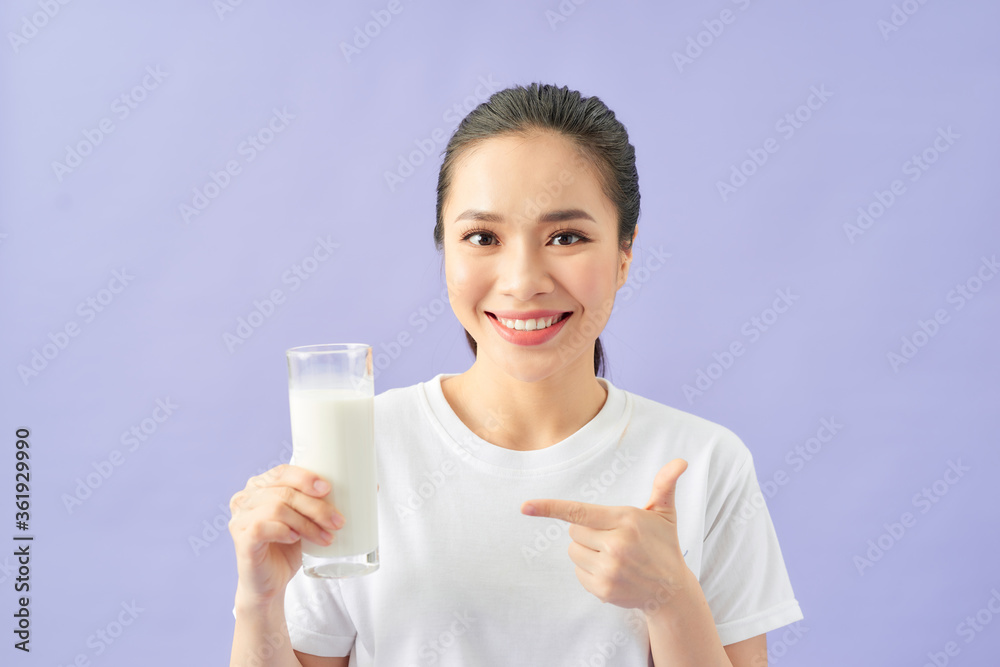 Young beautiful woman drinking a glass of milk over purple isolated background with surprise face pointing finger to herself Young beautiful woman drinking a glass of milk over purple isolated background with surprise face pointing finger to herself