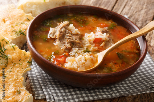 Kharcho soup with beef, rice with spices and vegetables, served with Georgian bread close-up on the table. horizontal