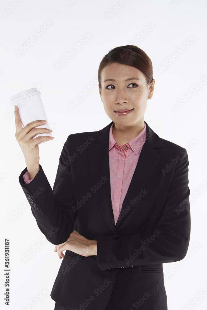 Businesswoman smiling and holding a disposable cup Businesswoman smiling and holding a disposable cup