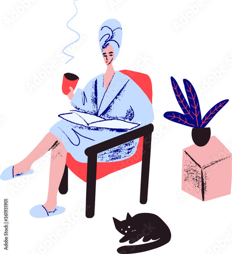 Young woman with a cup of tea in hand sitting on an armchair and reading a newspaper. Girl in a bathrobe with a towel on her head.