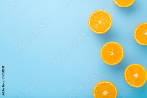 Bright halves of oranges. Fresh fruits. Empty place for text on light blue table background. Pastel color. Closeup. Top down view.