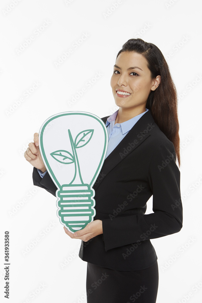 Cheerful businesswoman holding up a cut out light bulb Cheerful businesswoman holding up a cut out light bulb