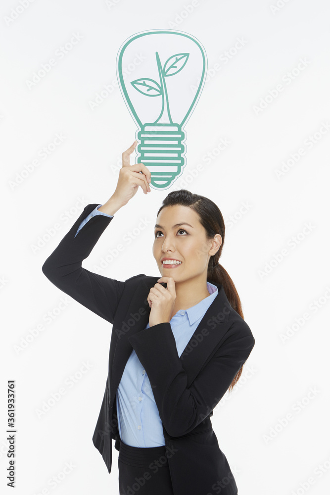 Businesswoman with a cut out light bulb, contemplating Businesswoman with a cut out light bulb, contemplating