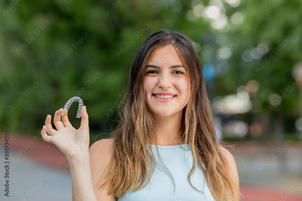custom made wallpaper toronto digitalBeautiful smiling Turkish woman is holding an invisalign bracer