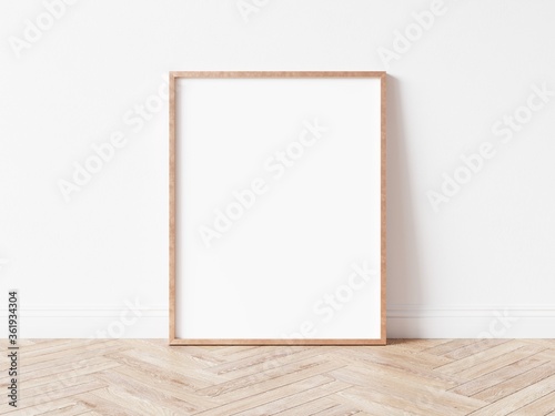 Fototapeta Naklejka Na Ścianę i Meble -  Vertical rose gold empty picture frame on wooden floor. Copper frame mock up. 3D illustration.