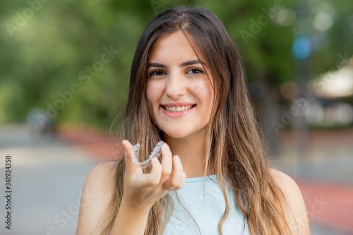 Wallpaper Mural Beautiful smiling Turkish woman is holding an invisalign bracer Torontodigital.ca
