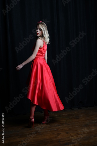 young and beautiful girl tries on her first evening red dress