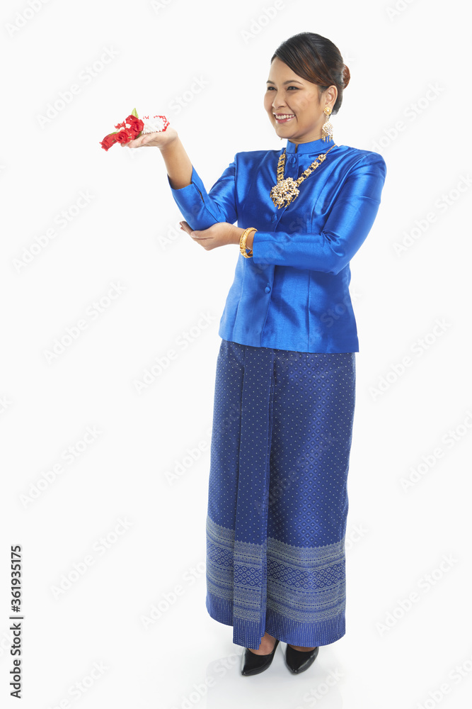 Woman in traditional clothing holding on to a flower garland Woman in traditional clothing holding on to a flower garland