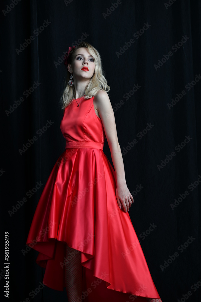 young and beautiful girl tries on her first evening red dress young and beautiful girl tries on her first evening red dress
