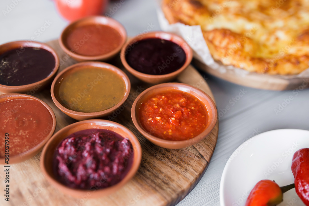 spicy sauces in round plates. cheese and vegetables around. close-up, top view. Georgian national cuisine spicy sauces in round plates. cheese and vegetables around. close-up, top view. Georgian national cuisine