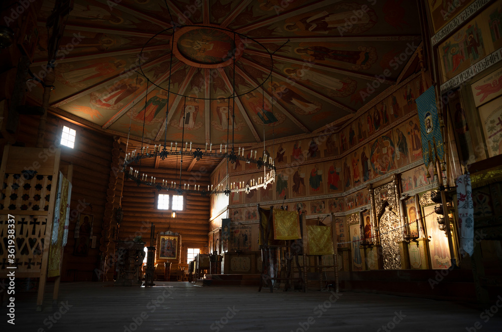 Fototapeta premium The interior of a wooden Russian temple. Without people. In natural light. Beautiful icons and carved furniture.