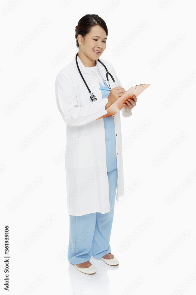 Medical personnel writing down notes on clip board Medical personnel writing down notes on clip board