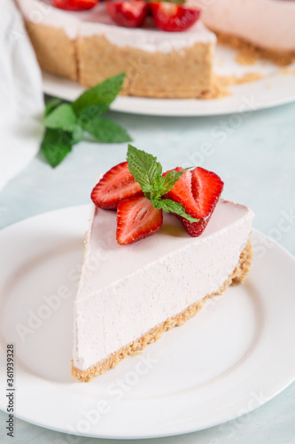 Sweet breakfast, delicious cheesecake with fresh strawberries and mint, homemade recipe without baking, on a blue stone table. Copy space.