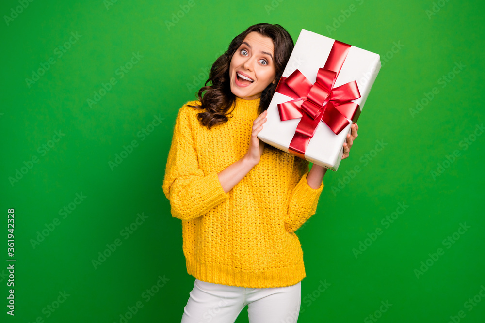 Photo of funny pretty lady hold big paper box red bow near head ear birthday party event gift wear knitted yellow sweater white trousers isolated vibrant green color background Photo of funny pretty lady hold big paper box red bow near head ear birthday party event gift wear knitted yellow sweater white trousers isolated vibrant green color background