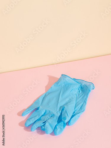 Blue medical gloves on yellow pink background. The concept of protection against disease. Copy space. © Plutmaverick