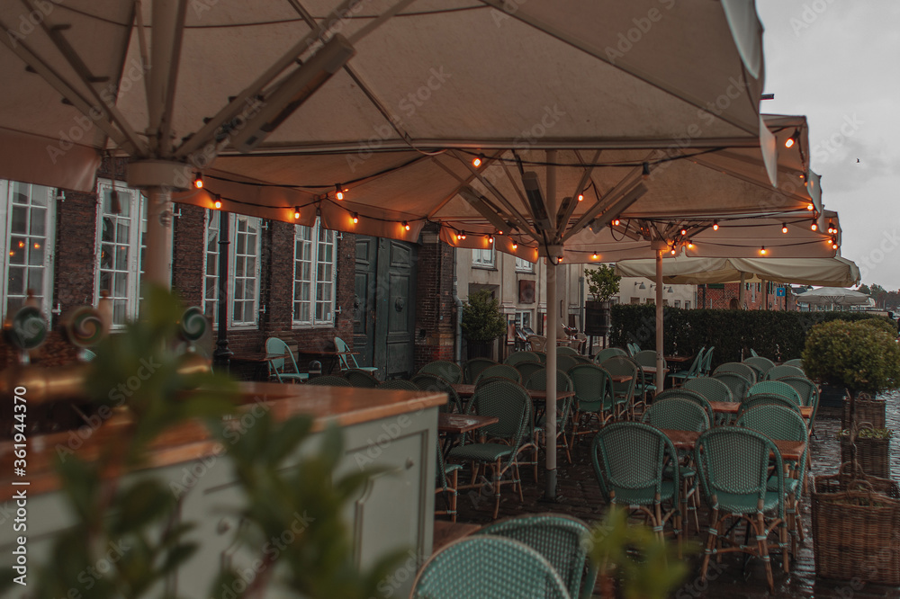 Fototapeta premium Selective focus of lighting on umbrellas of outdoor cafe in Copenhagen, Denmark