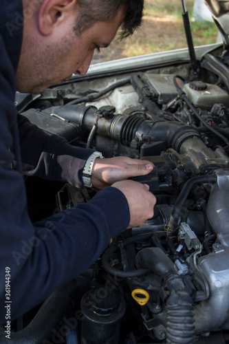 Car mechanic repairs car breakdowns, changes filter and changes spark plugs, ignition coil tip