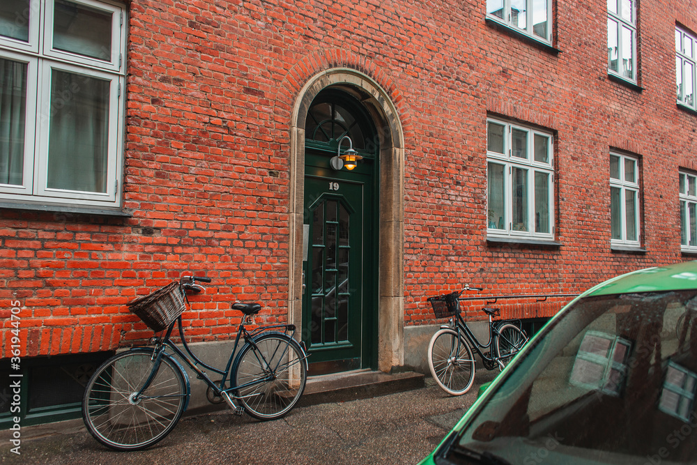 Lighting lantern on door of building with brick facade in Copenhagen, Denmark