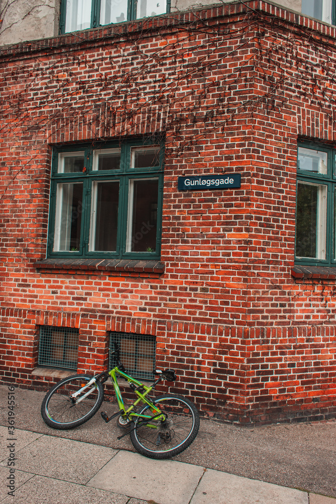 Bicycle on walkway near brick facade of building in Copenhagen, Denmark