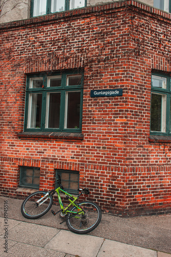 Bicycle on walkway near brick facade of building in Copenhagen, Denmark