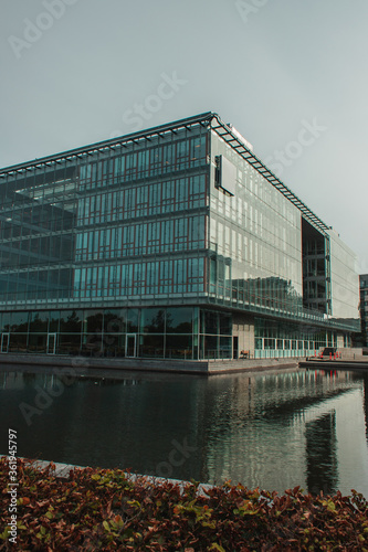 Photography Selective focus of building with glass facade near canal on urban street in Cope