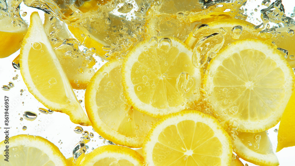 Lemon Slices falling deeply under water on white Lemon Slices falling deeply under water on white