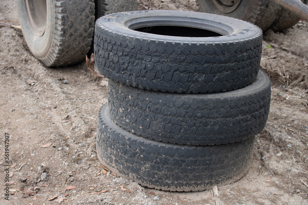 Three old tires stacked, close-up of a truck tire. Environmental pollution. Dump tires. Three old tires stacked, close-up of a truck tire. Environmental pollution. Dump tires.