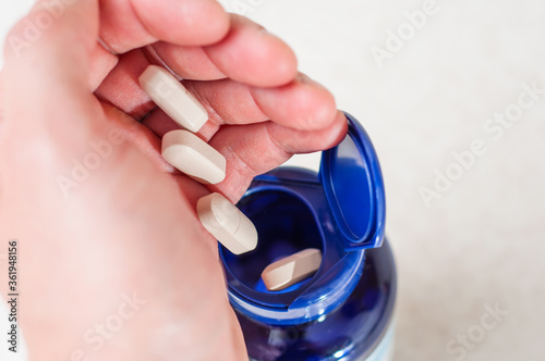 Dynamic photo of a pill falling from a hand into a medical jar
