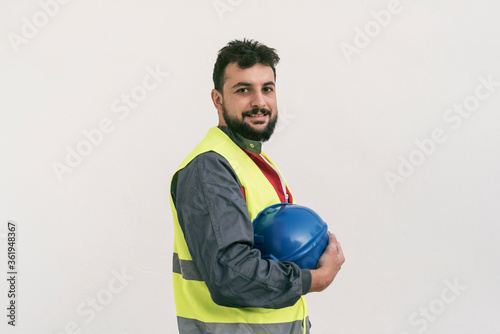 Construction worker portrait on white wall posing