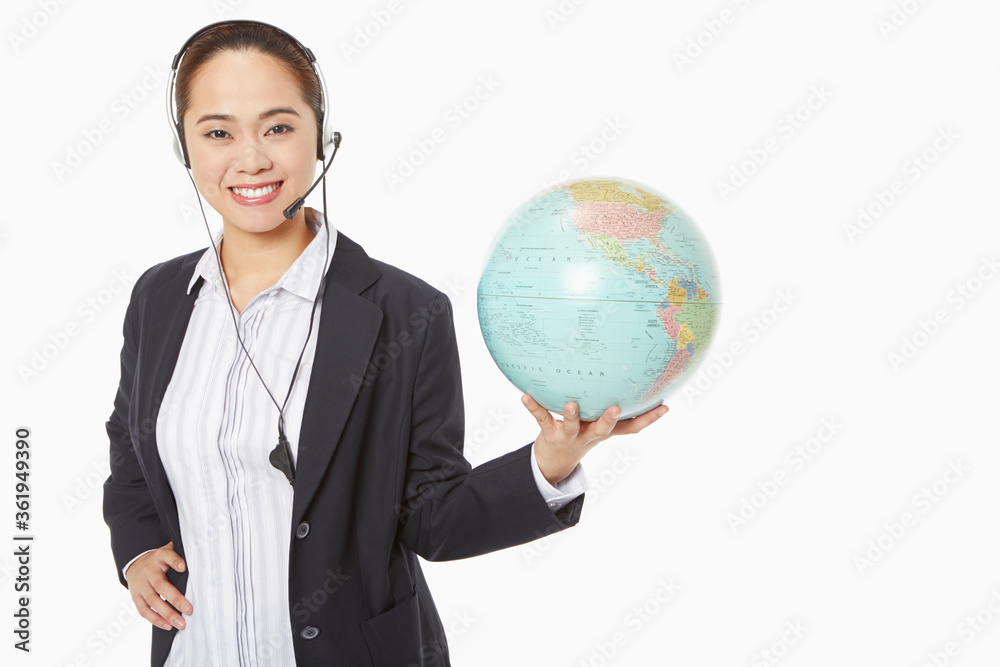 Businesswoman with headset holding a globe Businesswoman with headset holding a globe