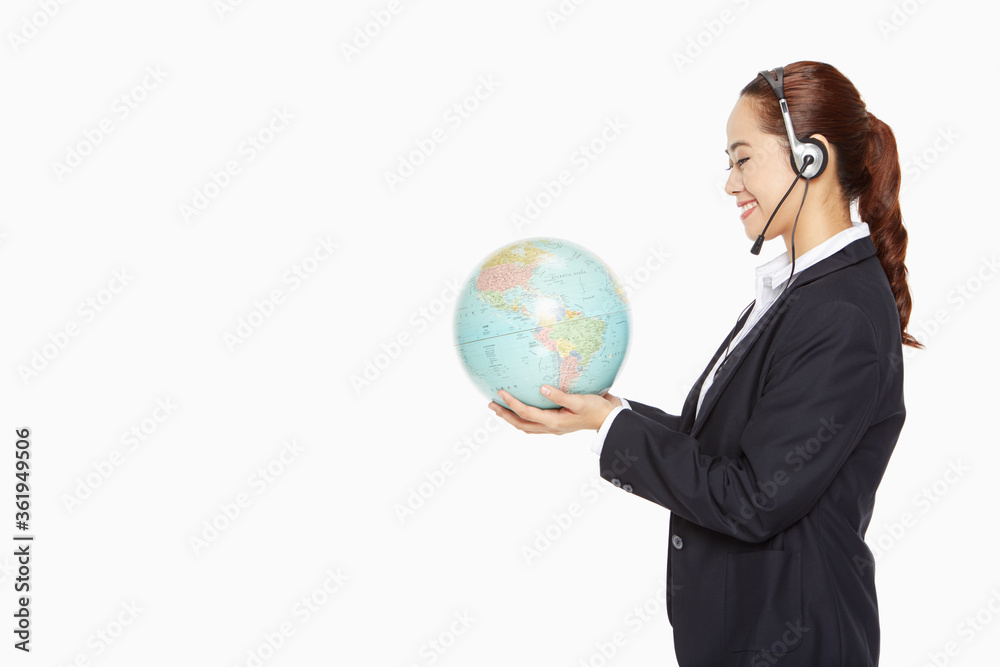 Businesswoman with headset holding a globe Businesswoman with headset holding a globe
