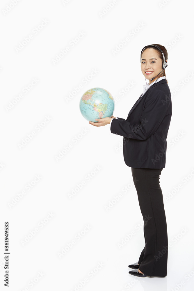 Businesswoman with headset holding a globe Businesswoman with headset holding a globe