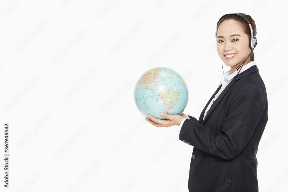 Businesswoman with headset holding a globe Businesswoman with headset holding a globe