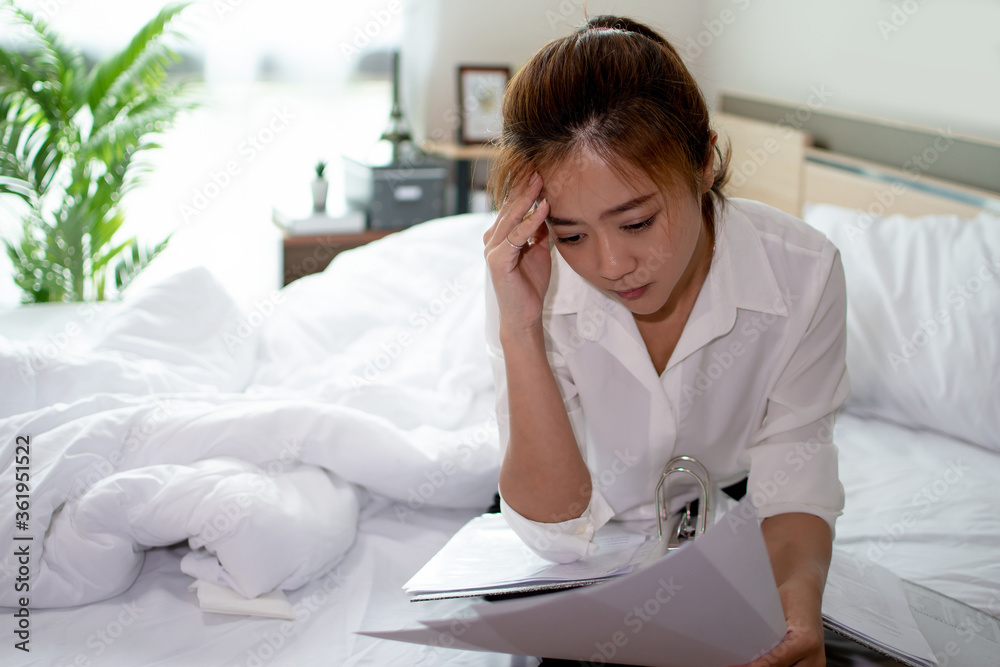 Business women feel stressed after work. She is working in her bedroom. Business women feel stressed after work. She is working in her bedroom.